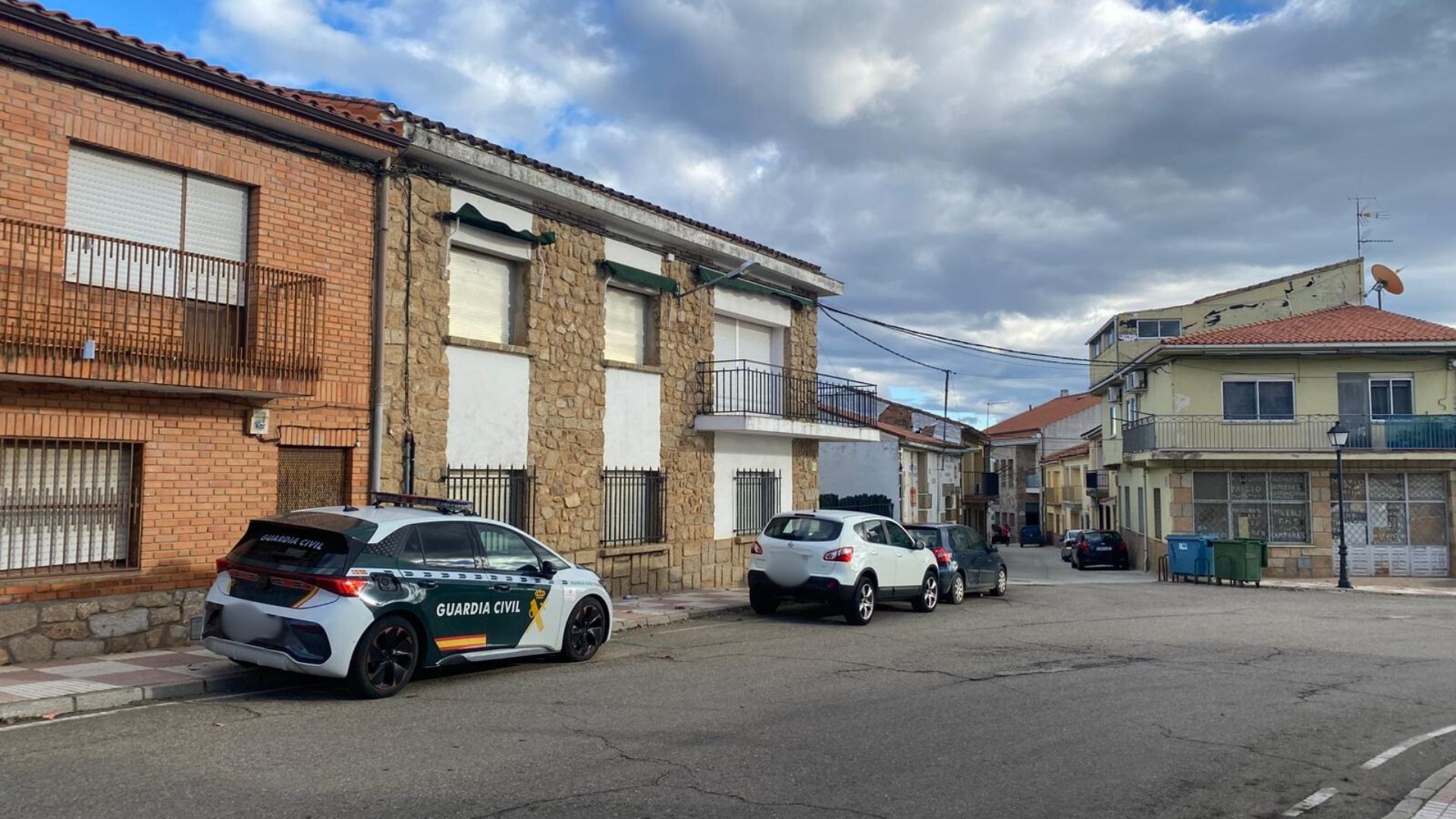 Vehículo de la Guardia Civil en la calle de acceso a otra calle en la que se encuentra la vivienda en la cual un hombre se ha atrincherado