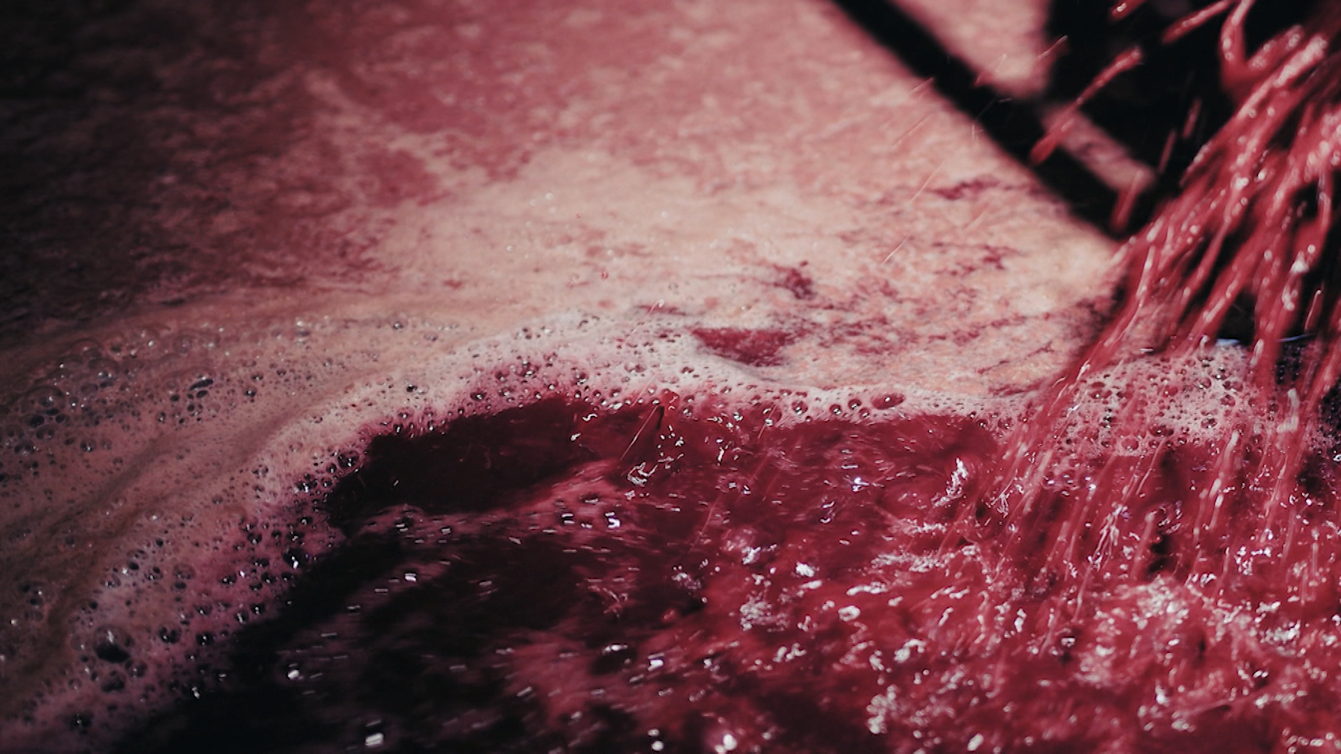 Vino tinto cayendo a un recipiente