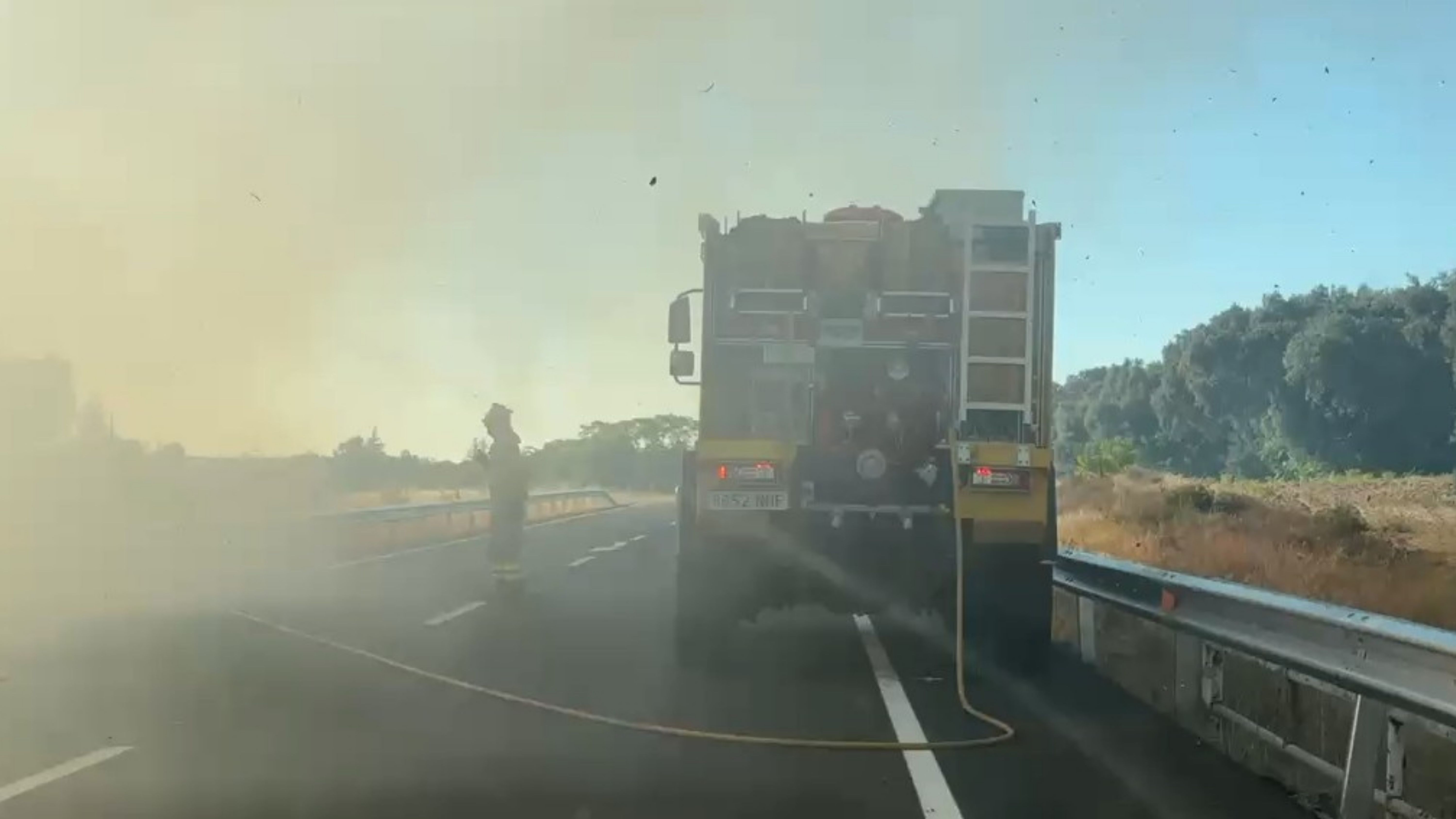 Bomberos del Ayuntamiento de Badajoz trabajando en la extinción del incendio junto a la carretera N-432.