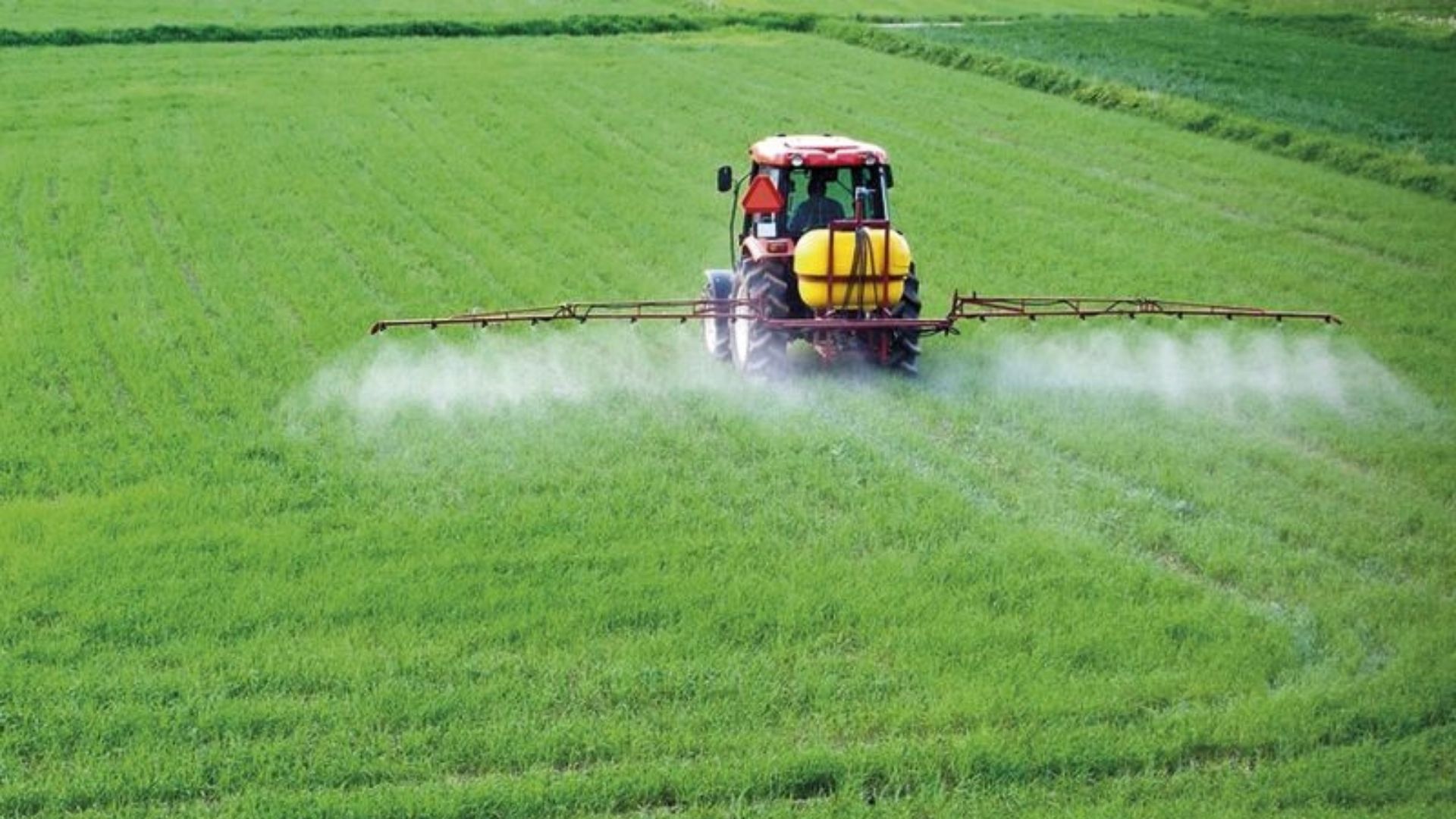 Maquinaria fertilizando el campo en una imagen de archivo