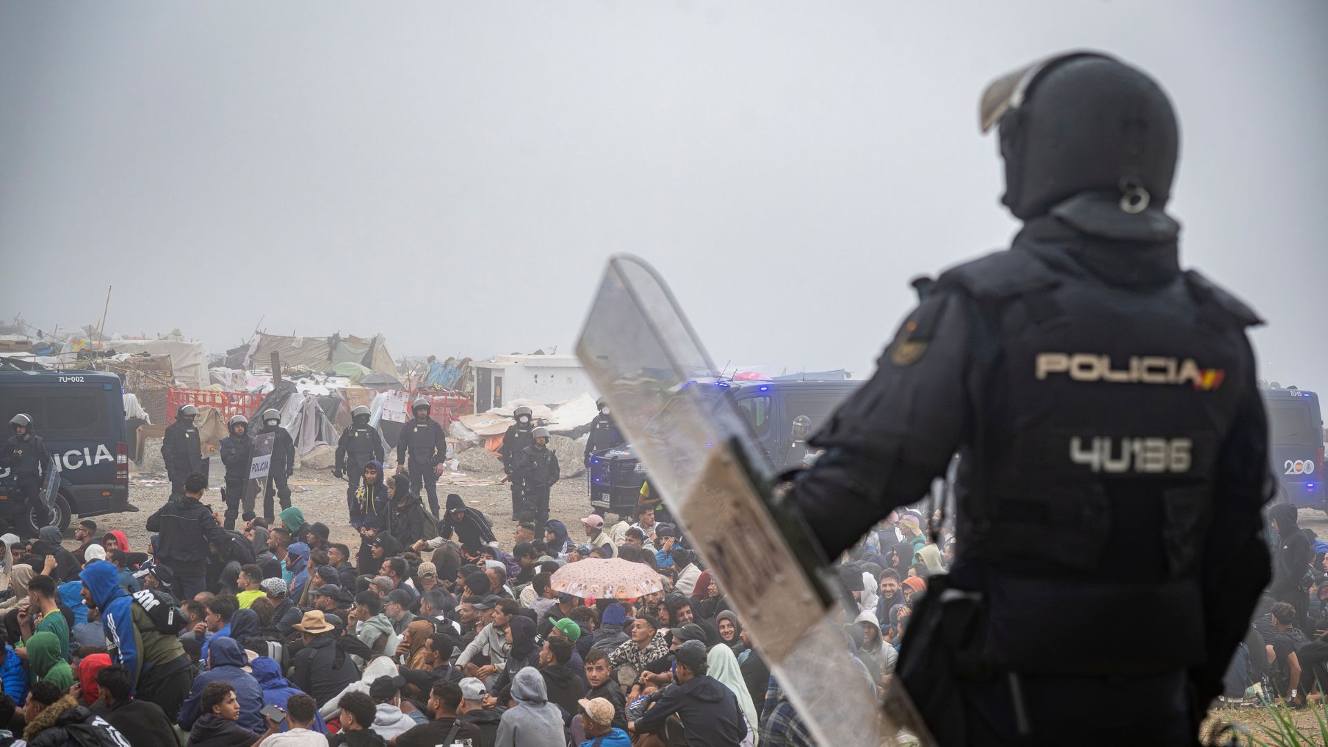 Agentes de la Policía Nacional intervienen durante el proceso de desalojo del embolsamiento de migrantes en la playa de El Trampolín, a 4 de octubre de 2026