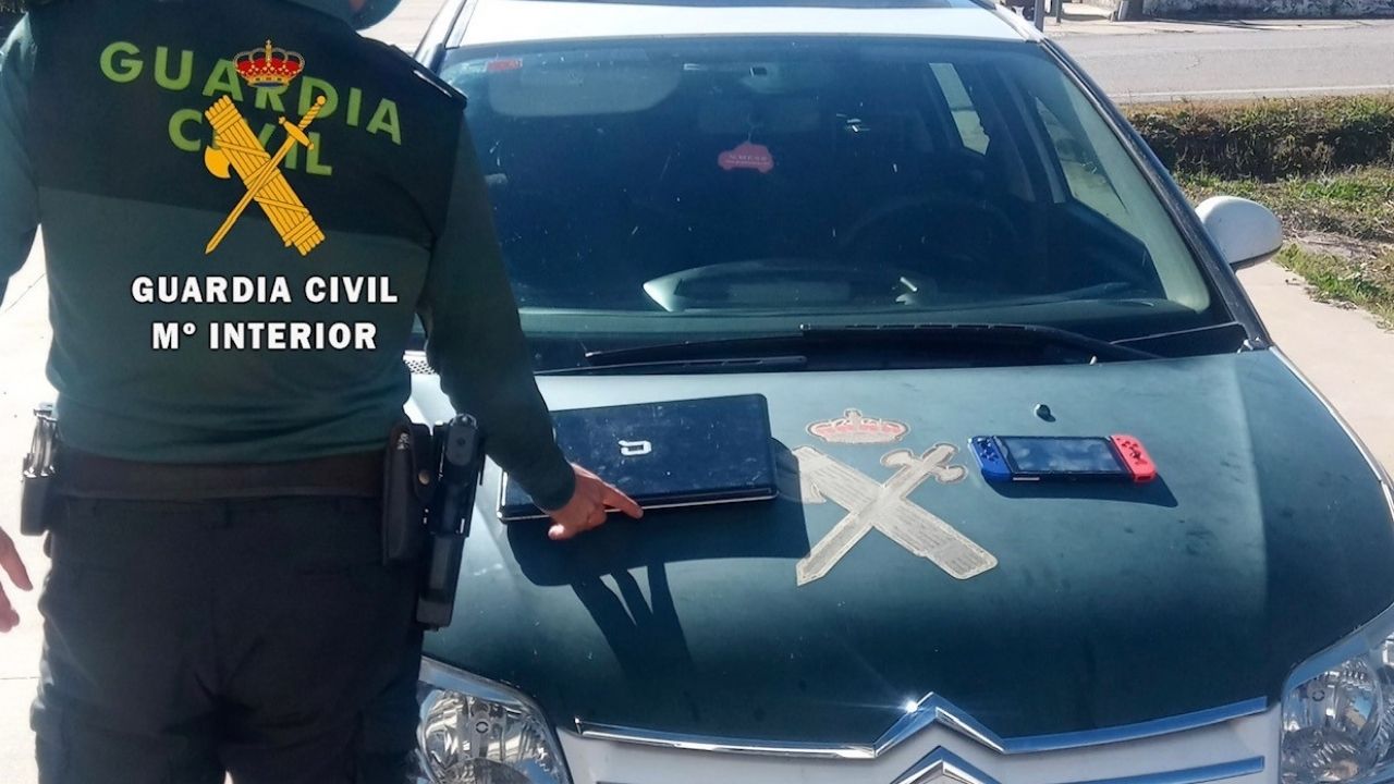 Un agente muestra algunos de los objetos recuperados en la casa y que supuestamente habían sido robados