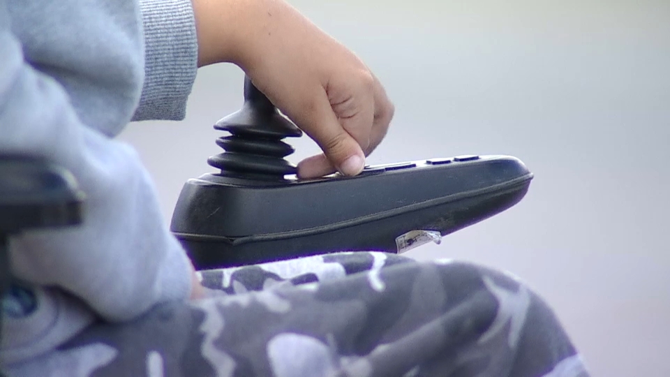 Niño en silla de ruedas eléctrica
