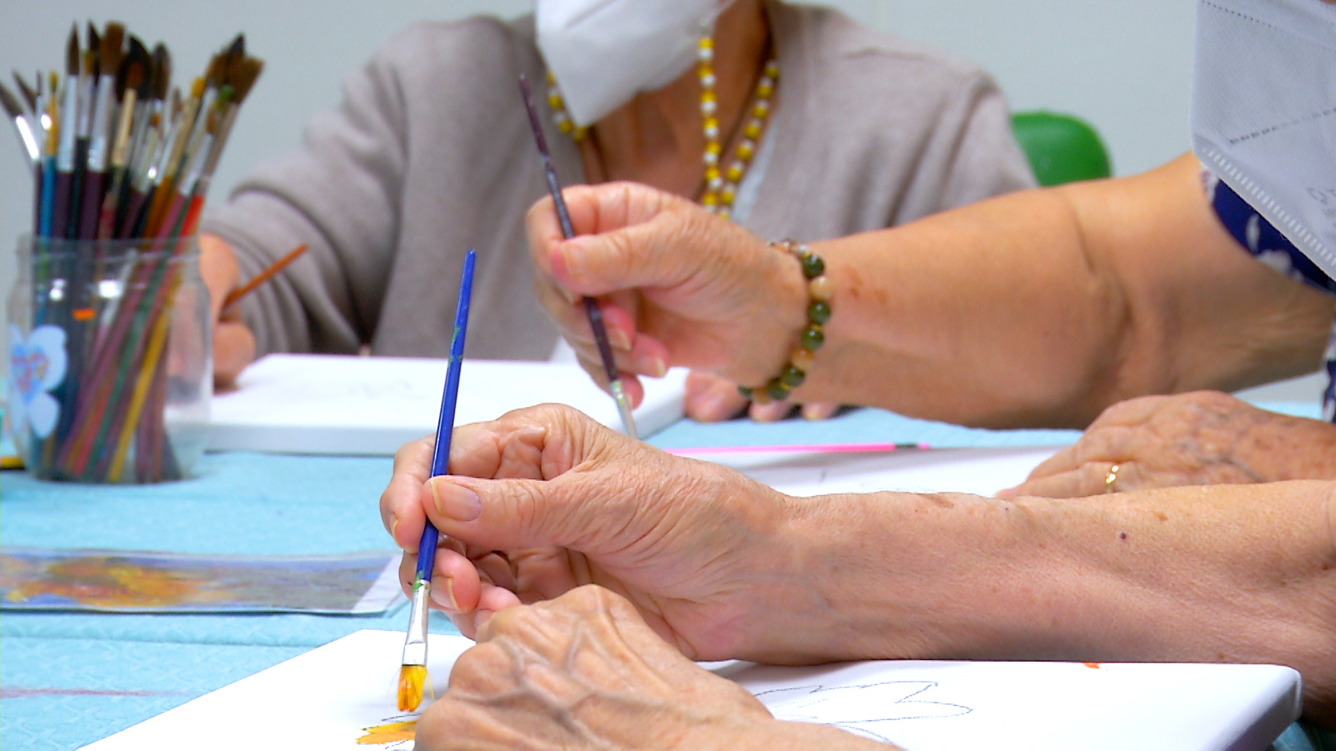 Manos de mujeres pintando con pincel