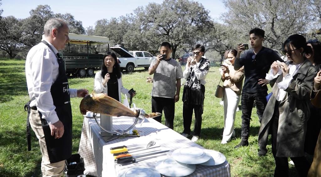 Ciudadanos chinos degustando jamón ibérico en la dehesa