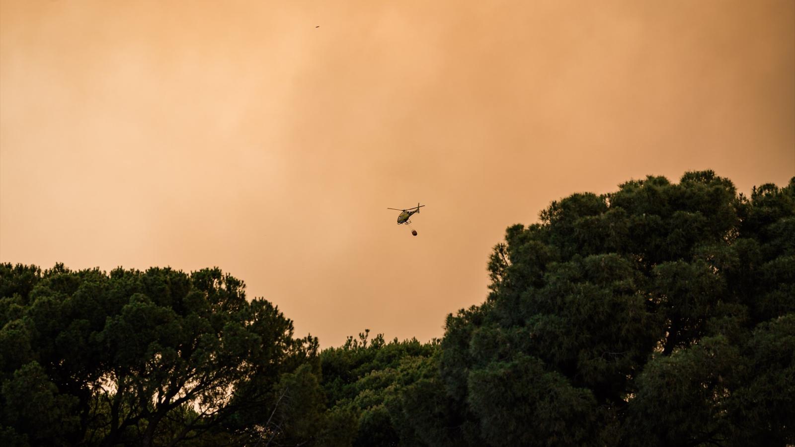 Un helicóptero colabora en la extinción del fuego, a 23 de julio de 2026, en San Martín de Valdeiglesias, Madrid