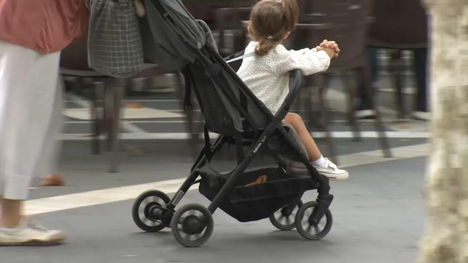 Niña pequeña en un carrito de bebé en una imagen de archivo