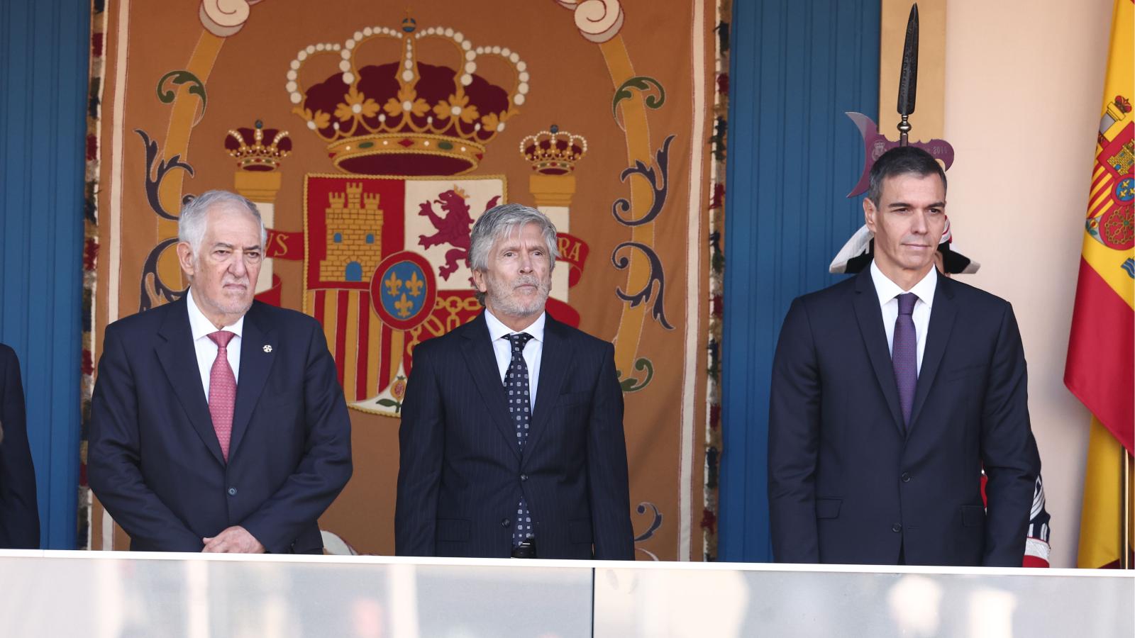 El presidente del Tribunal Constitucional, Cándido Conde-Pumpido; el ministro del Interior, Fernando Grande-Marlaska, y el presidente del Gobierno, Pedro Sánchez, durante el acto solemne de homenaje a la bandera nacional y desfile militar por el 12 de octubre, Día de la Hispanidad.